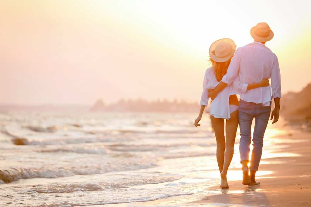 A happy couple walking on the beach