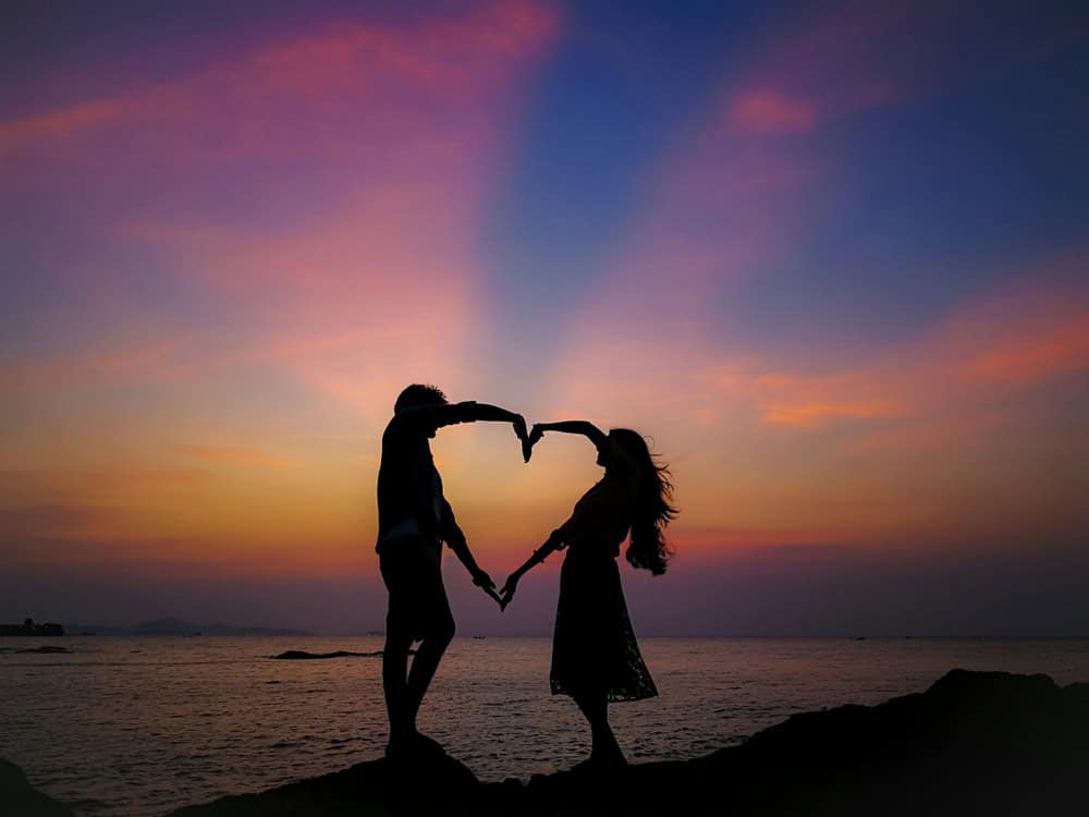 A couple celebrates the sunset on a beach in Pattaya.
